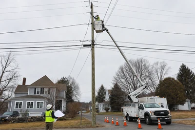Telecom field workers performing make-ready pole rearrangement with bucket truck
